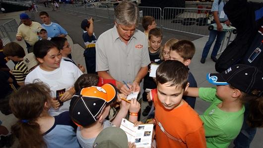 Young fans get autographs from 1998 Indy 500 winner Eddie Cheever on Community Day at the Indianapolis Motor Speedway.