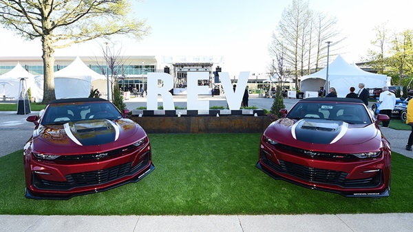 Two camaros and the REV sign