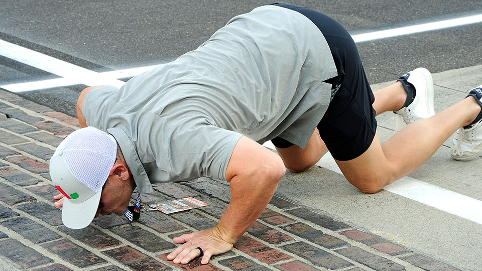 A man kisses the bricks at the Brickyard 400