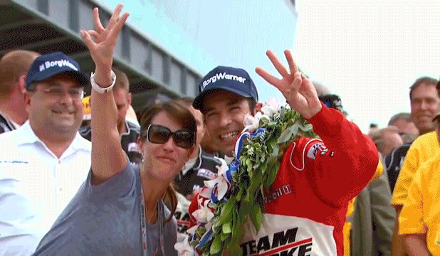 Helio Castroneves celebrates in victory lane with a bottle of milk.